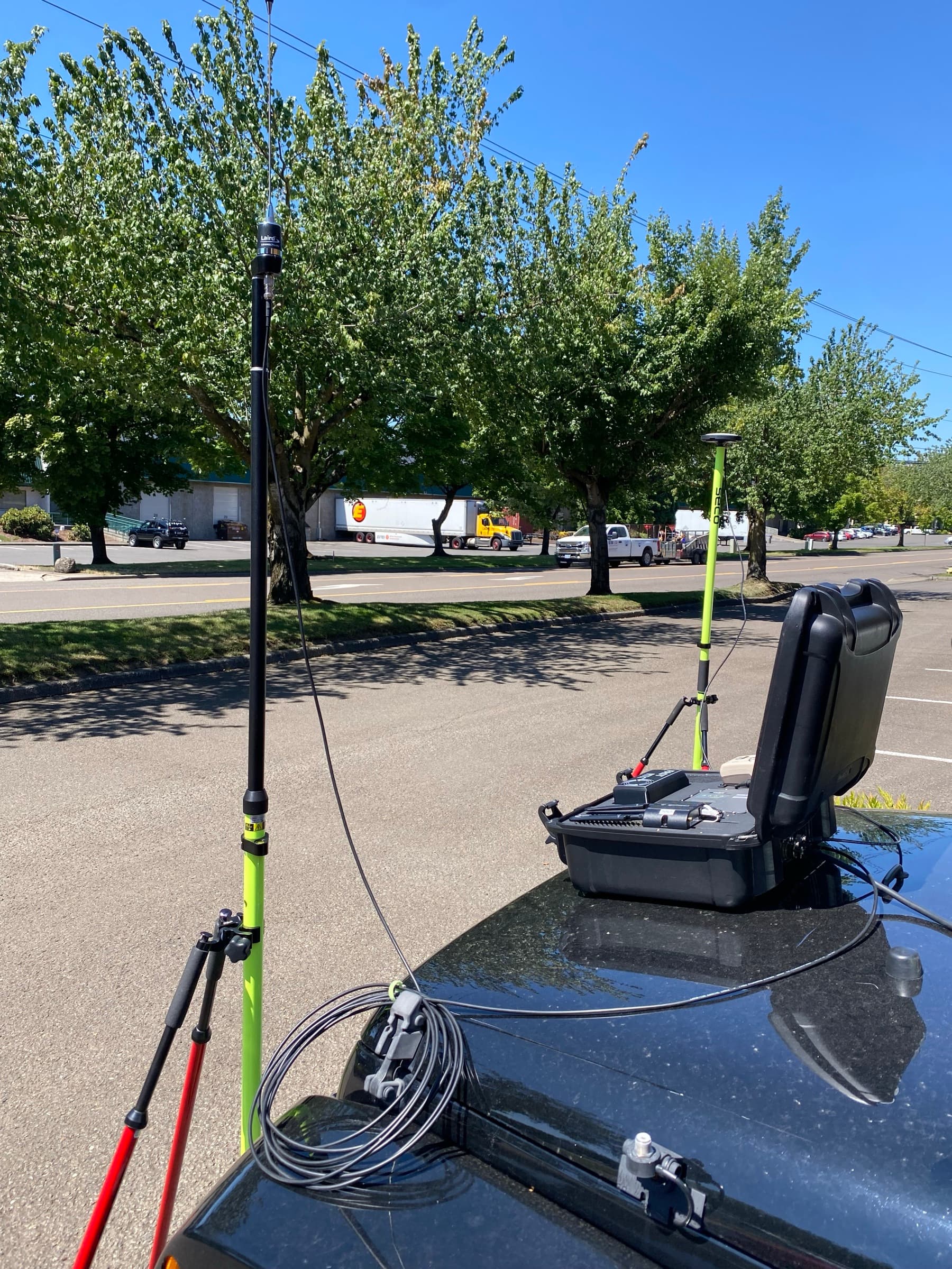 Temporary base deployed off a vehicle hood — UHF mast and GNSS antenna